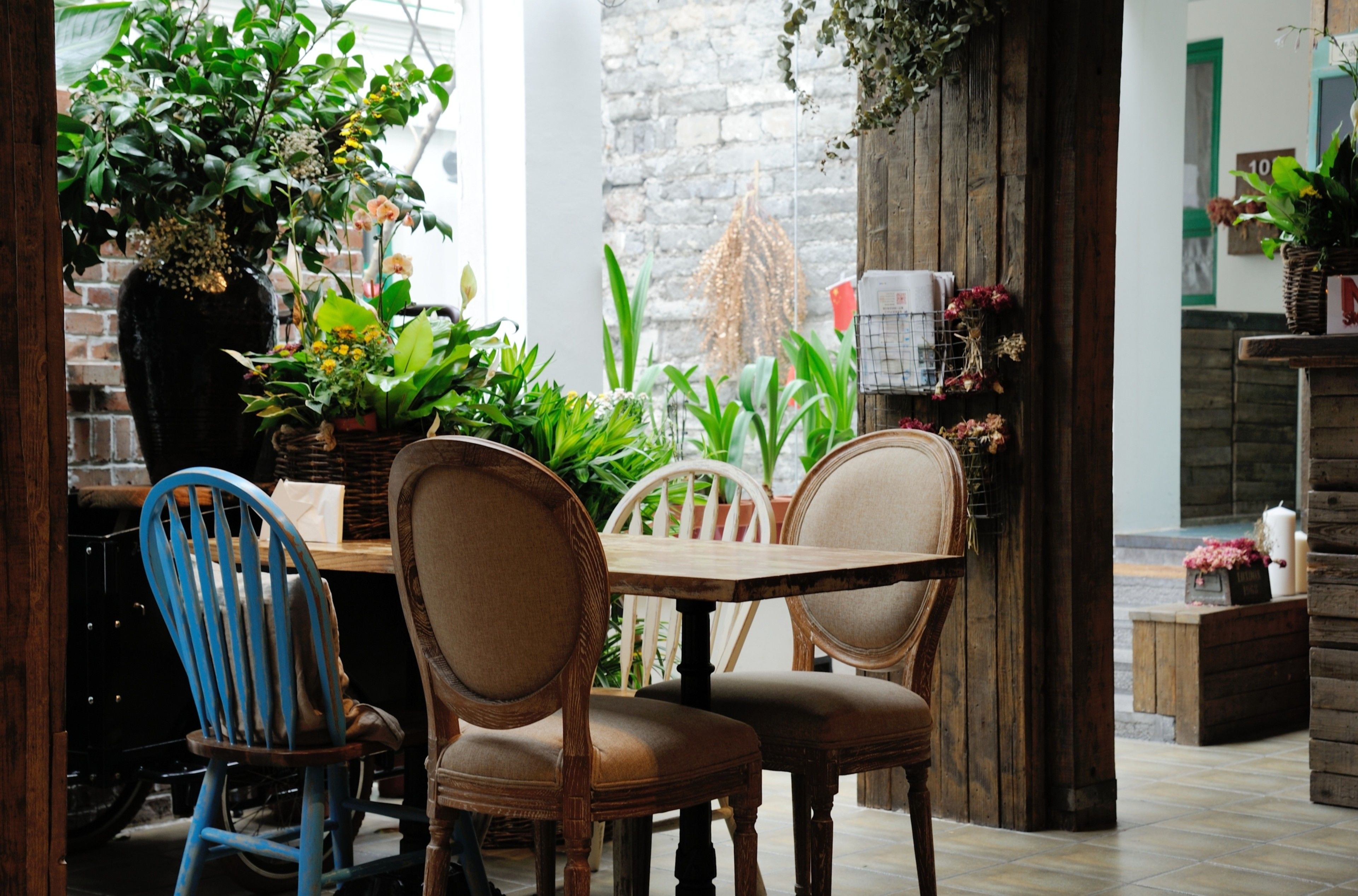 A rustic dining area with wooden furniture and potted plants.