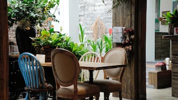 A rustic dining area with wooden furniture and potted plants.