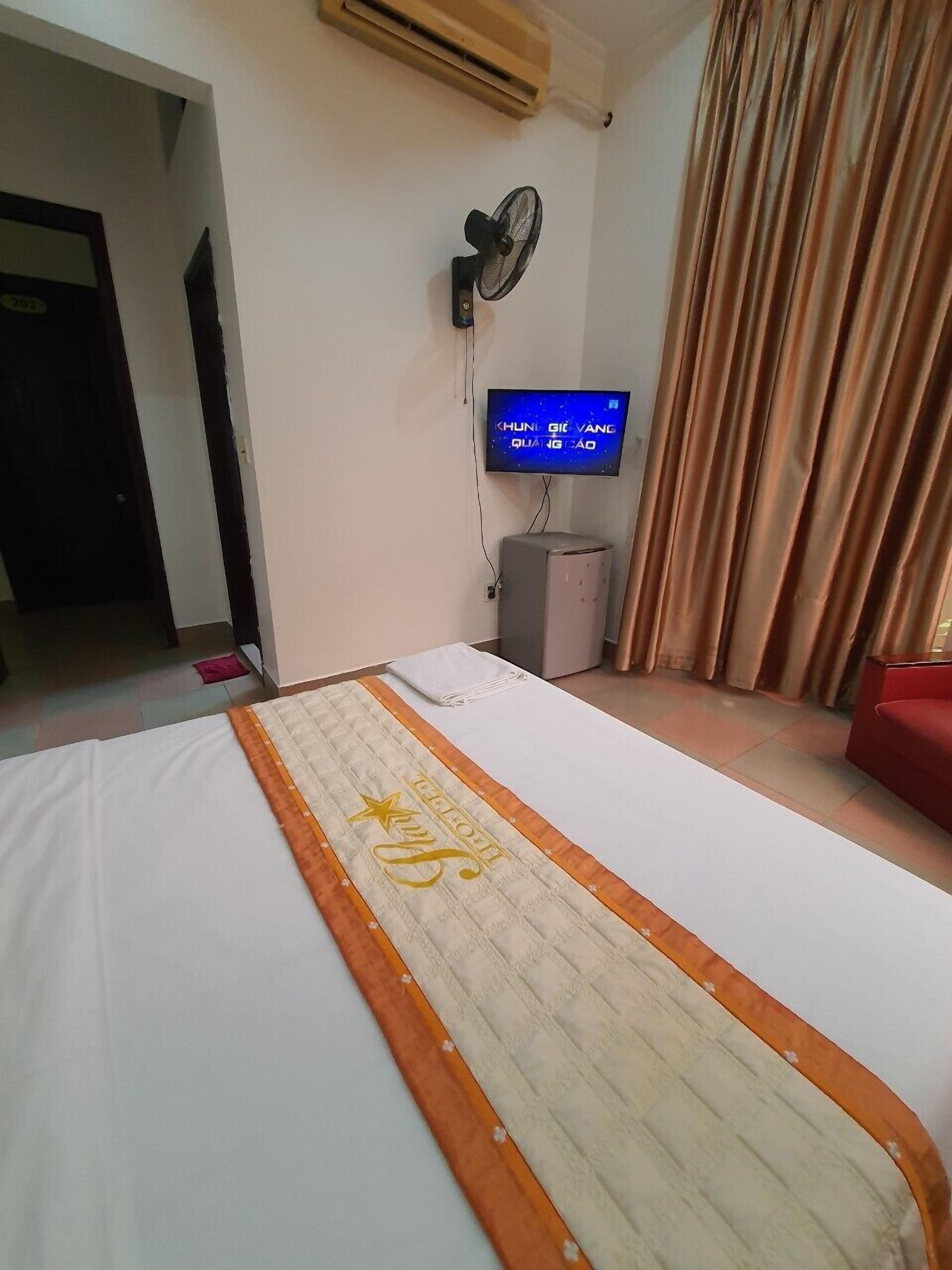 Habitació d'hotel amb un llit, una televisió, aire condicionat i una cortina.