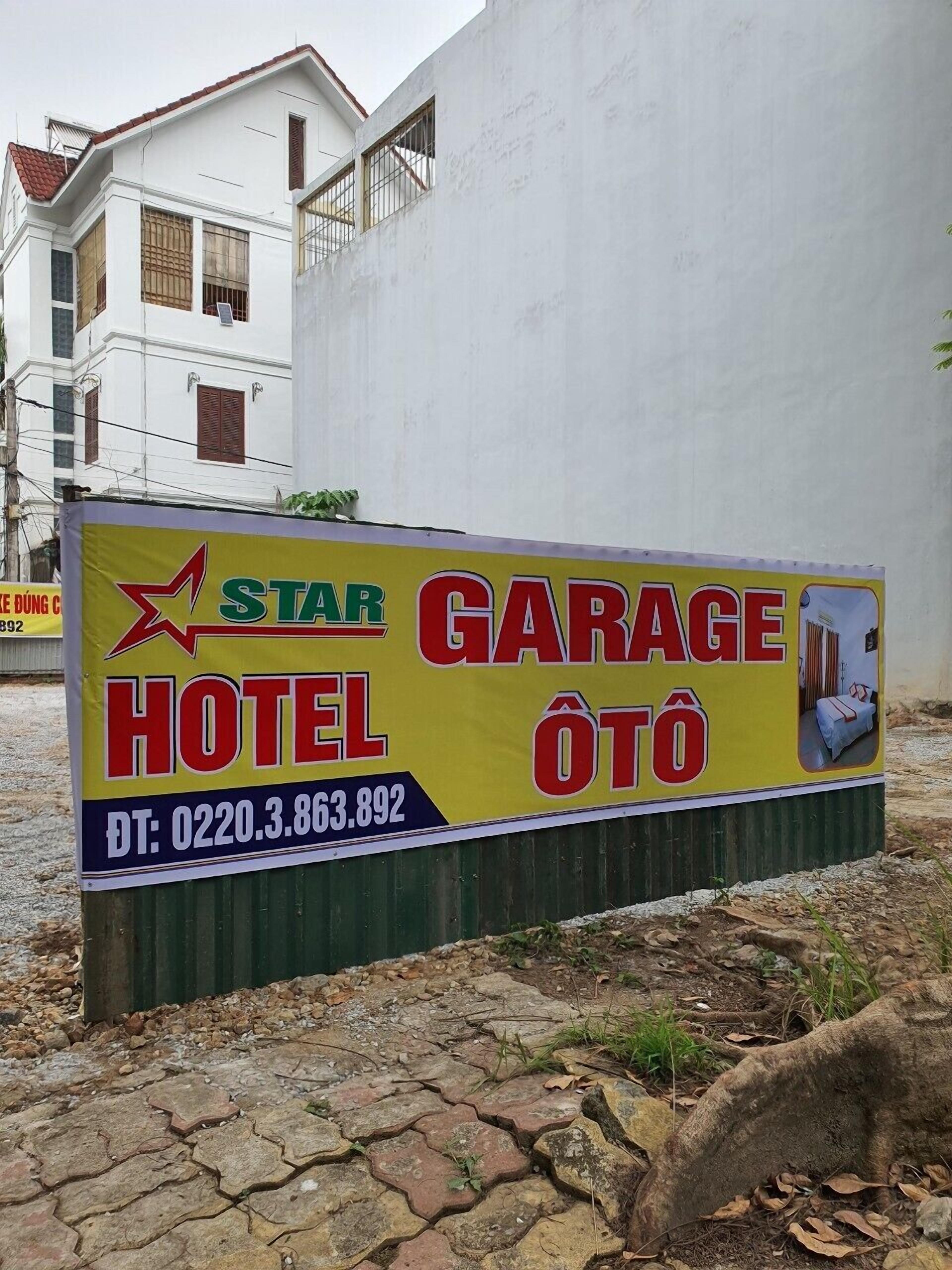 A sign for a Star Garage Hotel with contact details.