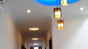 A hotel hallway with a blue-lit ceiling, recessed lighting, and a tiled floor. - Star Hotel Hai Duong (Hai Phong)