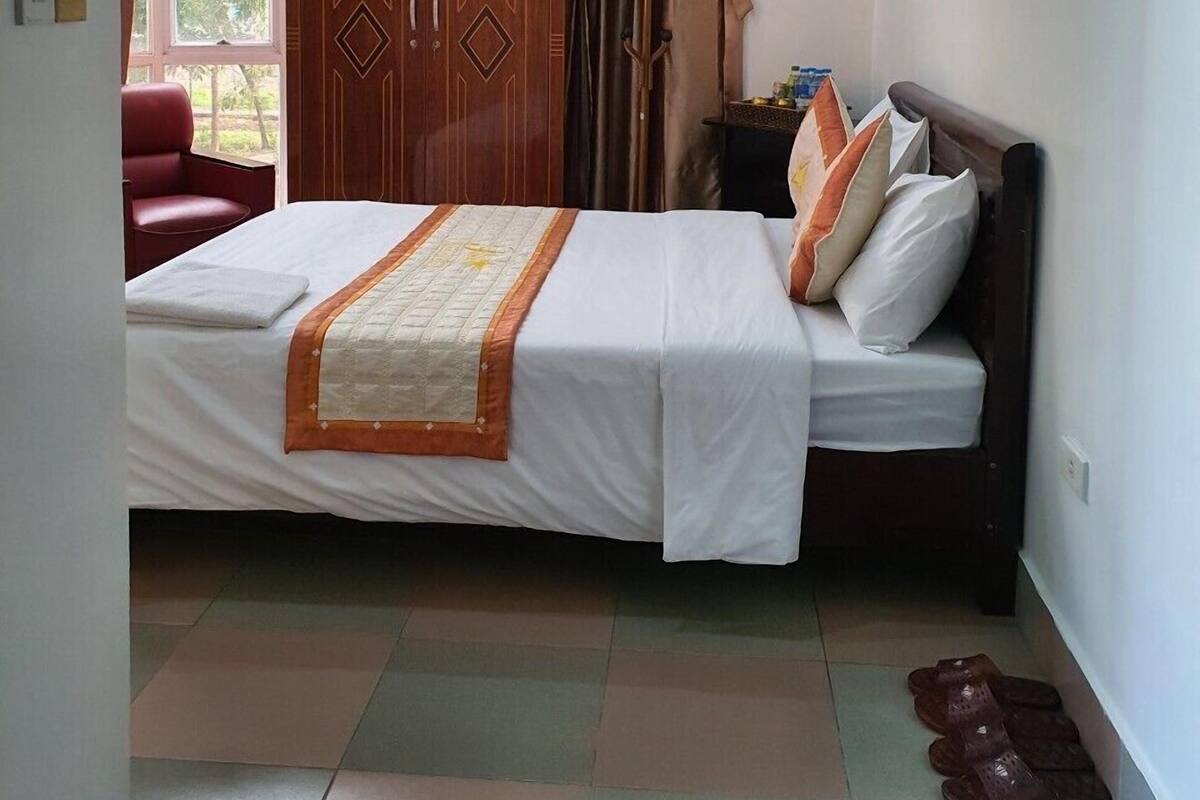 A bedroom with a bed, a wardrobe, a chair, and a nightstand.