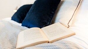 Un libro abierto sobre una cama con una colcha blanca y azul.