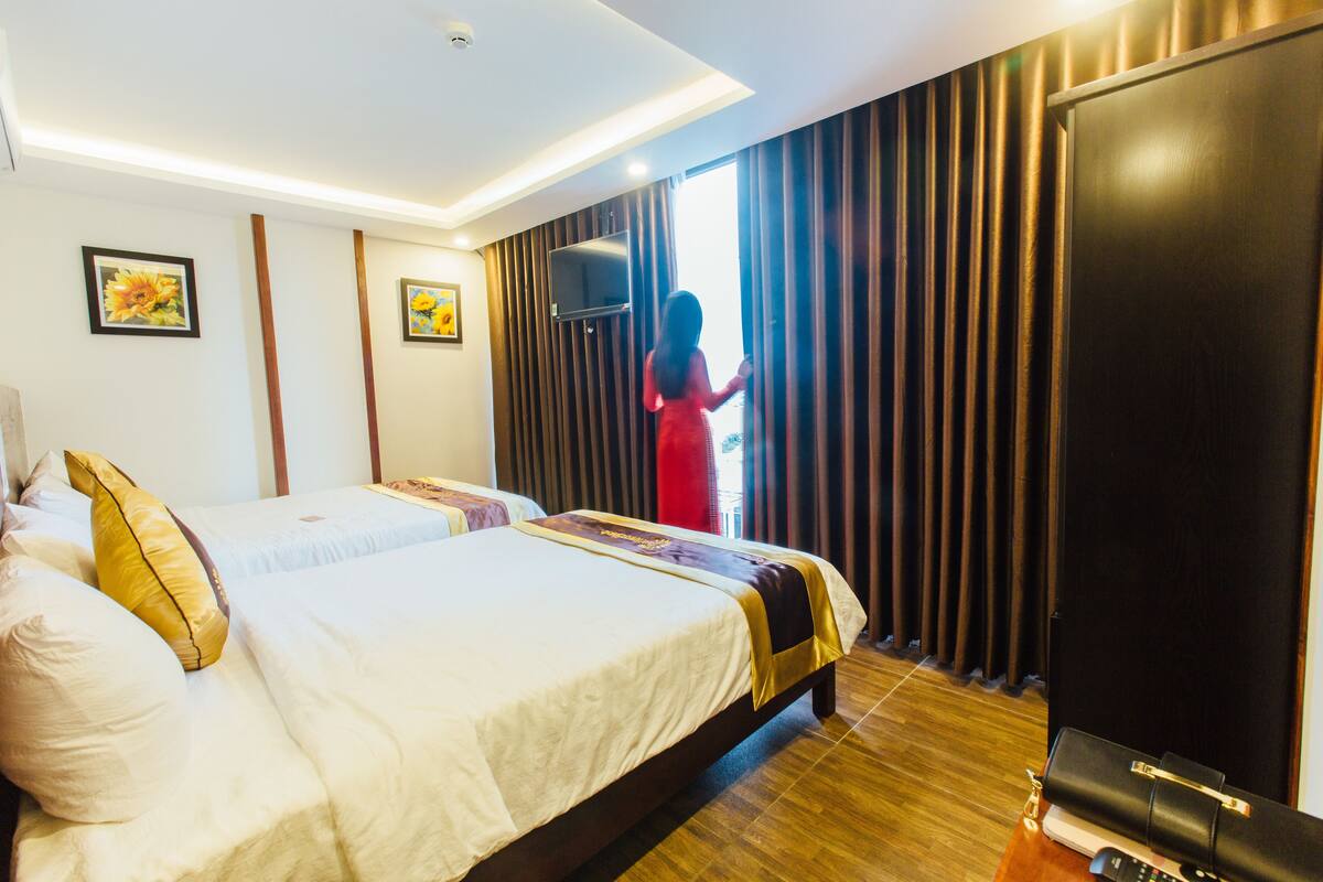 Una habitación de hotel con una cama grande, un armario y un televisor sobre un mueble.