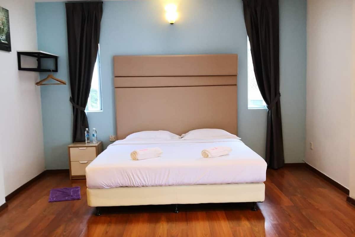 A bedroom with a large bed, two bedside tables, a nightstand, a window with curtains, and a skylight.