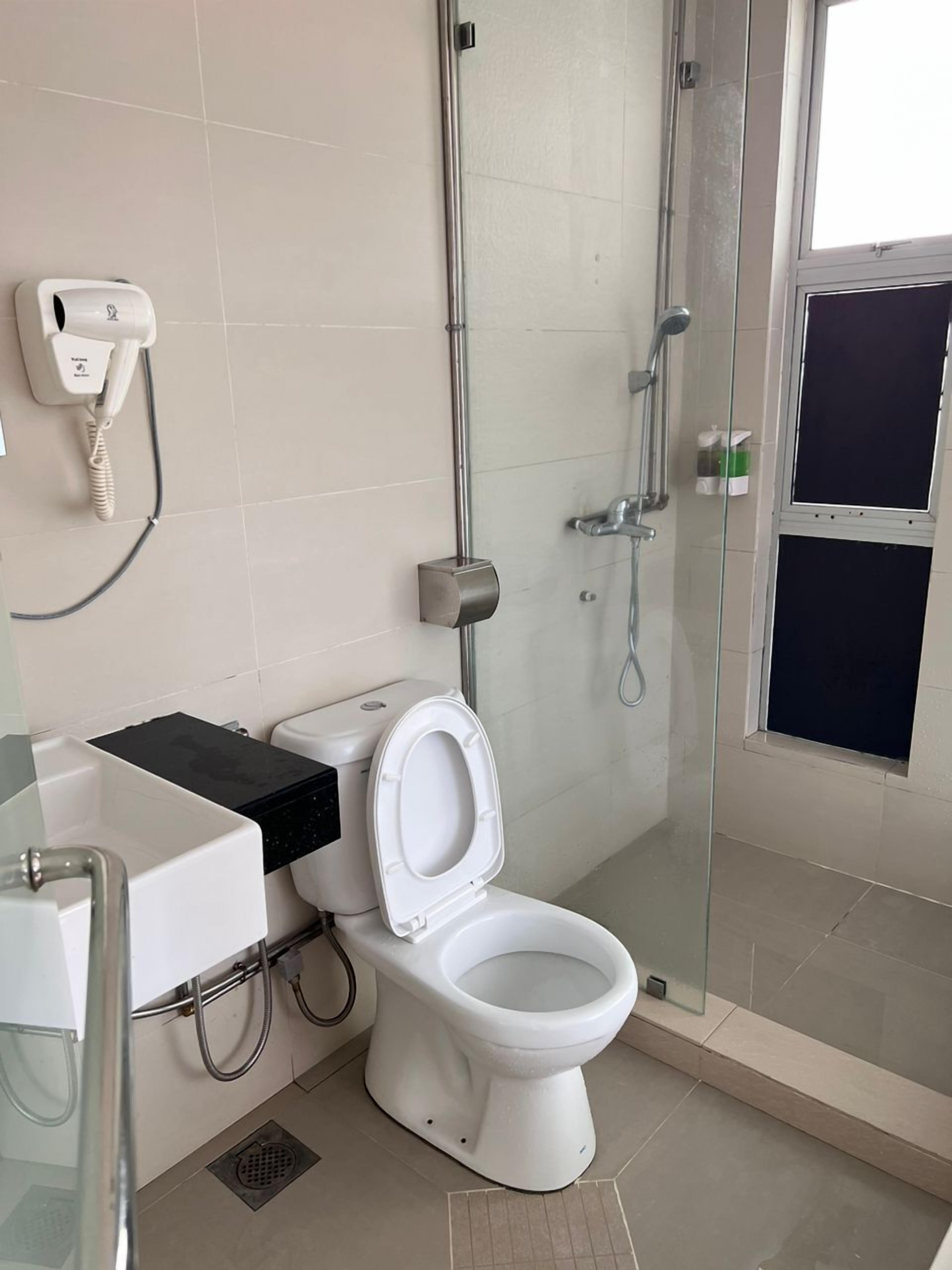 A modern bathroom with a toilet, bidet, and glass-enclosed shower.