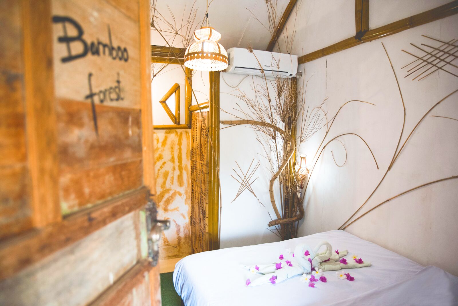 Una habitación con cama, aire acondicionado de pared y una pared decorativa con motivos abstractos.