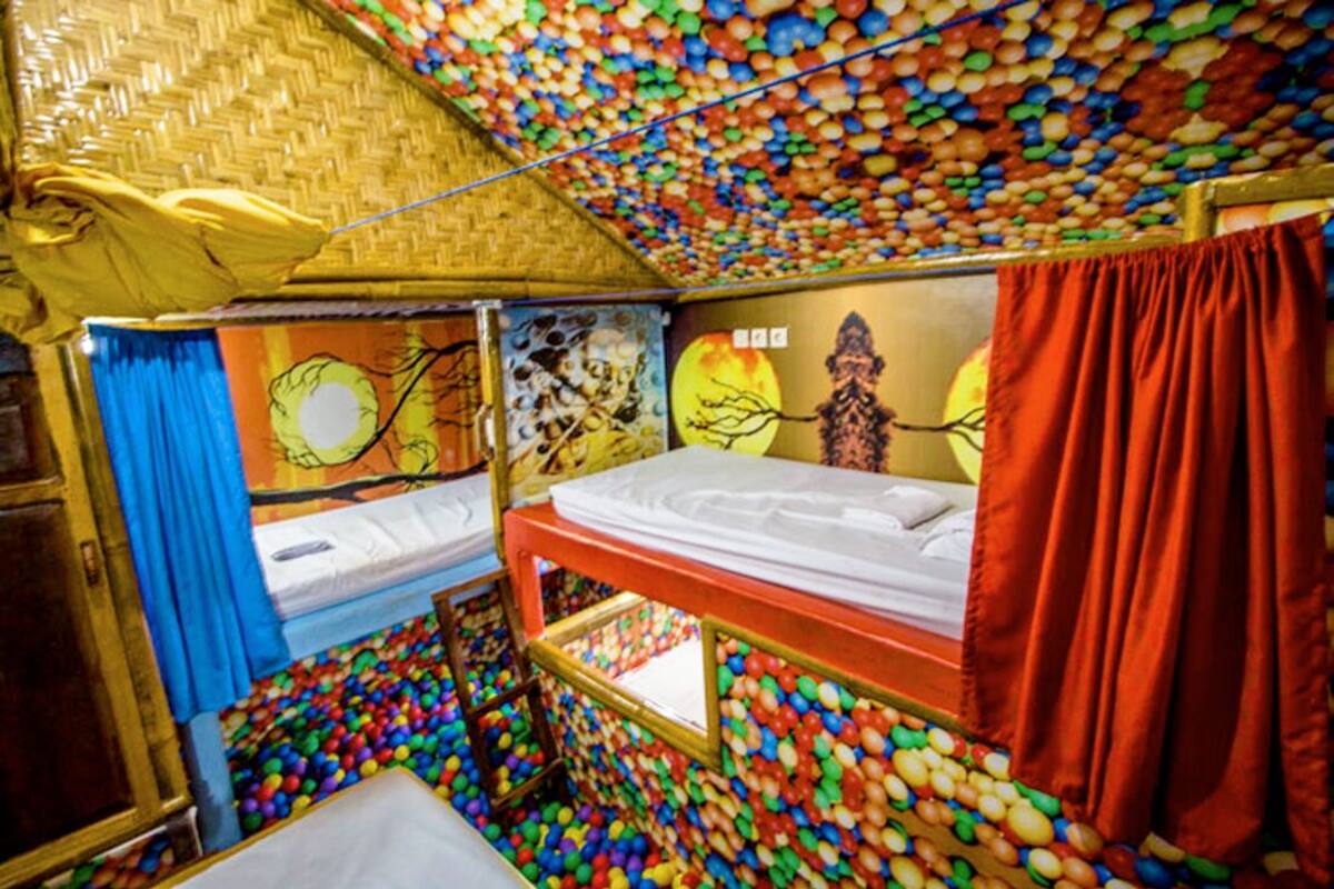 Ein Zimmer mit Etagenbetten, bunten Wänden und einer Bällecke.