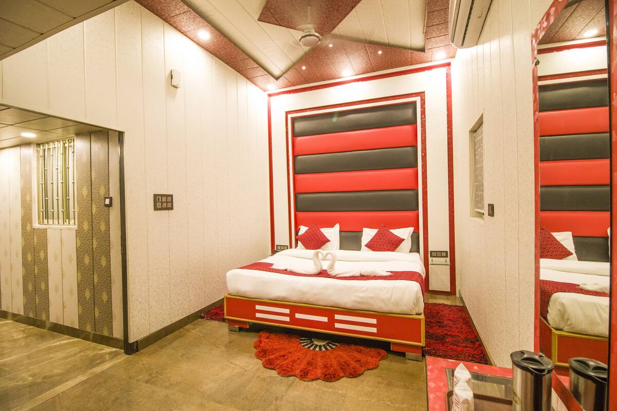 A hotel room with a large bed, a red and white color scheme, and a modern design.