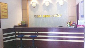 A reception area with a counter, two bar stools, and a wall-mounted sign.