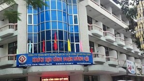 A hotel with a curved facade, multiple balconies, and flags.