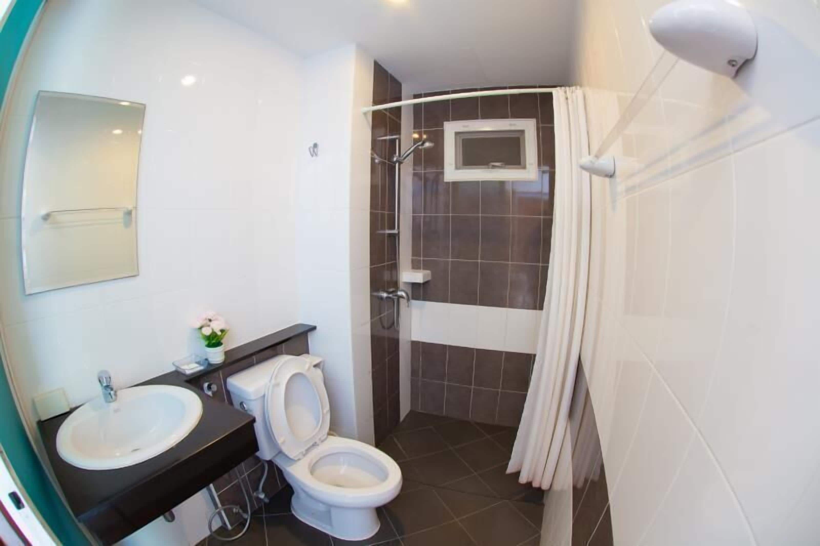 Et moderne badeværelse med vask, toilet og bruseniche.