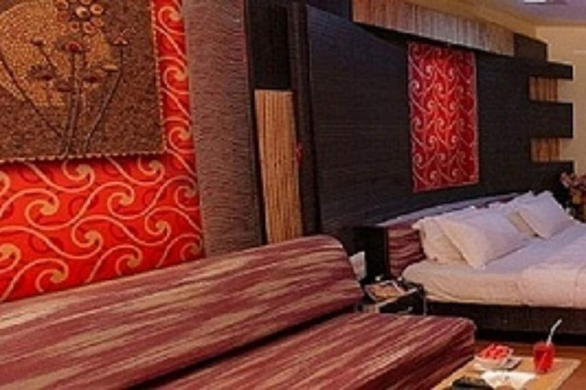 Une chambre à coucher avec un lit, un canapé, une télévision et un escalier.