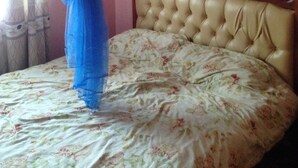 A bedroom with a bed, a canopy, a floral bedspread, and a wooden headboard. - Tulos Apartment (Ruiru)