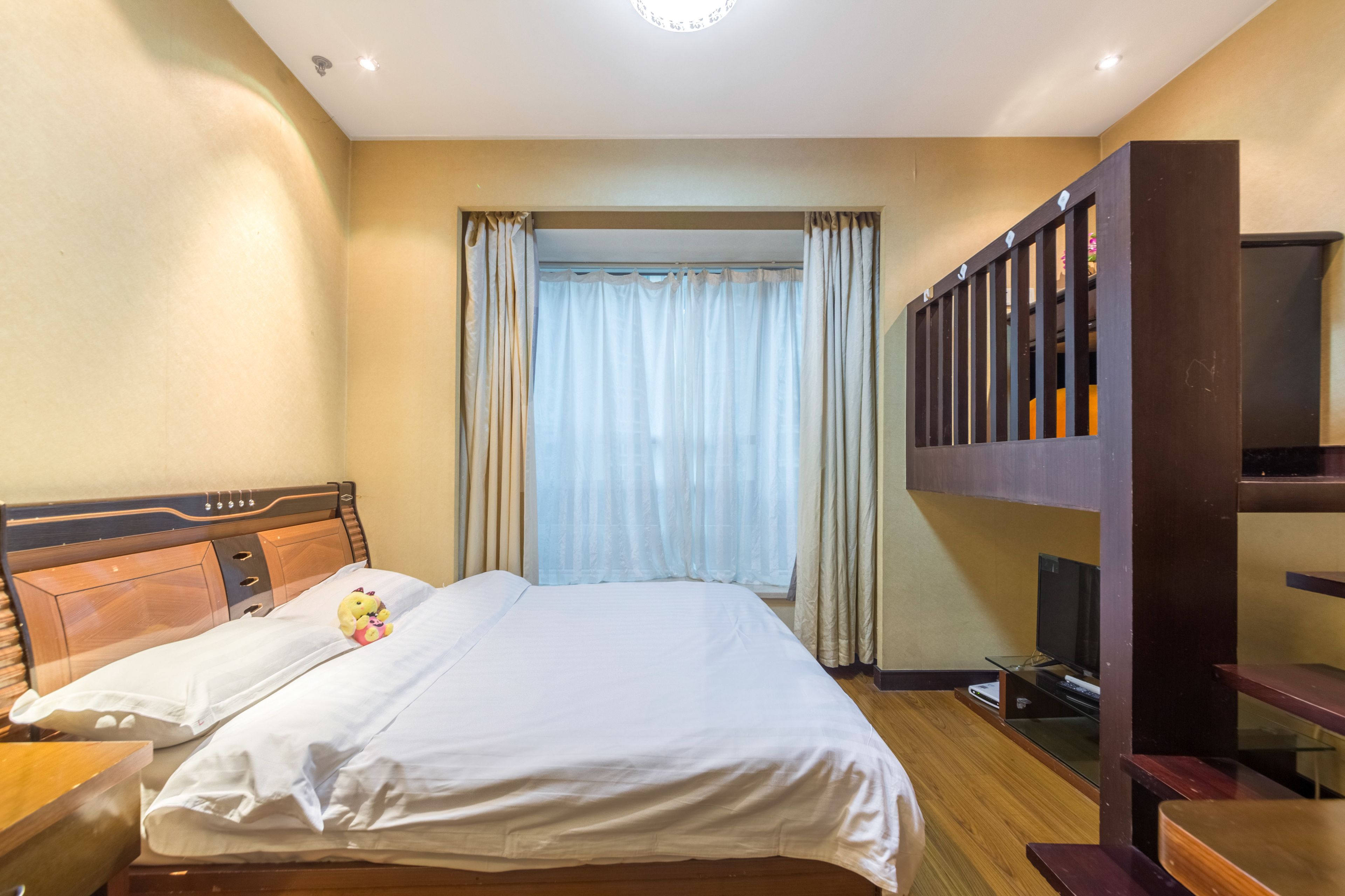 Una habitación de hotel con una cama, un televisor y un escritorio de madera.