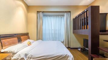 Una habitación de hotel con una cama, un televisor y un escritorio de madera.