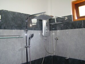 Habitación triple Deluxe, 1 habitación, vista al jardín | Regadera en el baño