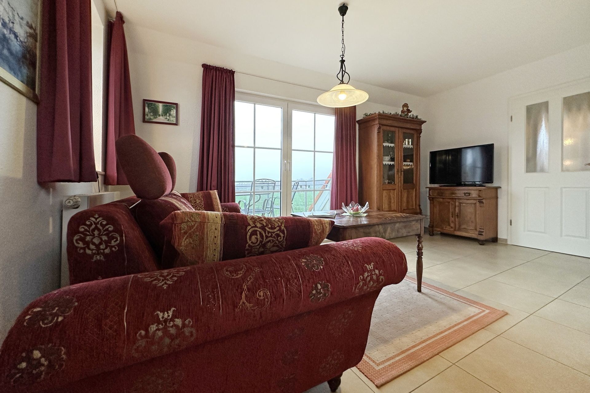 Un salon avec un canapé, un téléviseur et un meuble.