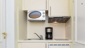 A compact kitchenette with a microwave, coffee maker, and a small sink. - Apartment Aurelia - Apartments in the North Sea Garden Park (Esens)