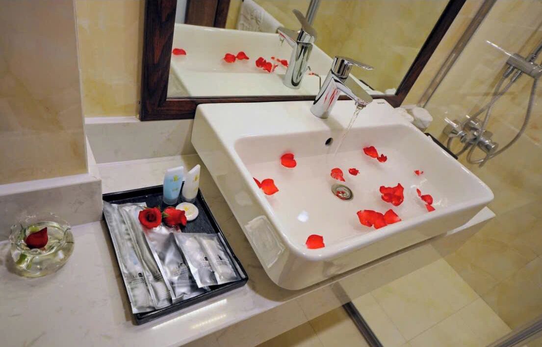 Ein Badezimmer mit einem weißen Waschbecken, einem Spiegel und einer Duschkabine.