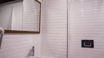 Un baño moderno con un lavamanos blanco, un espejo y un inodoro.