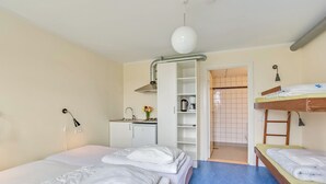 A hotel room with a bunk bed, a desk with a kettle, a wardrobe, and a bathroom visible through an open door. - Boeslunde Bed & Breakfast (Skælskør)