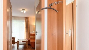 Ein Hotelzimmer mit Holztür, einem kleinen Tisch und einem Stuhl.