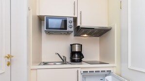 Une petite cuisine équipée d’un four à micro-ondes, d’une machine à café et d’un réfrigérateur.