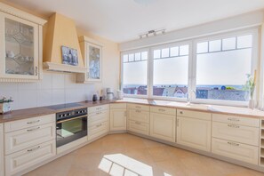 Eine Küche mit großem Fenster, einem eingebauten Backofen und Blick auf die Stadt.