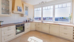 A kitchen with a large window, a built-in oven, and a view of the city. - Lighthouse - House Sun & Sea (Sierksdorf)