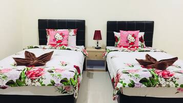 Habitación doble con dos camas, cada una con ropa de cama floral y almohadas de Hello Kitty.