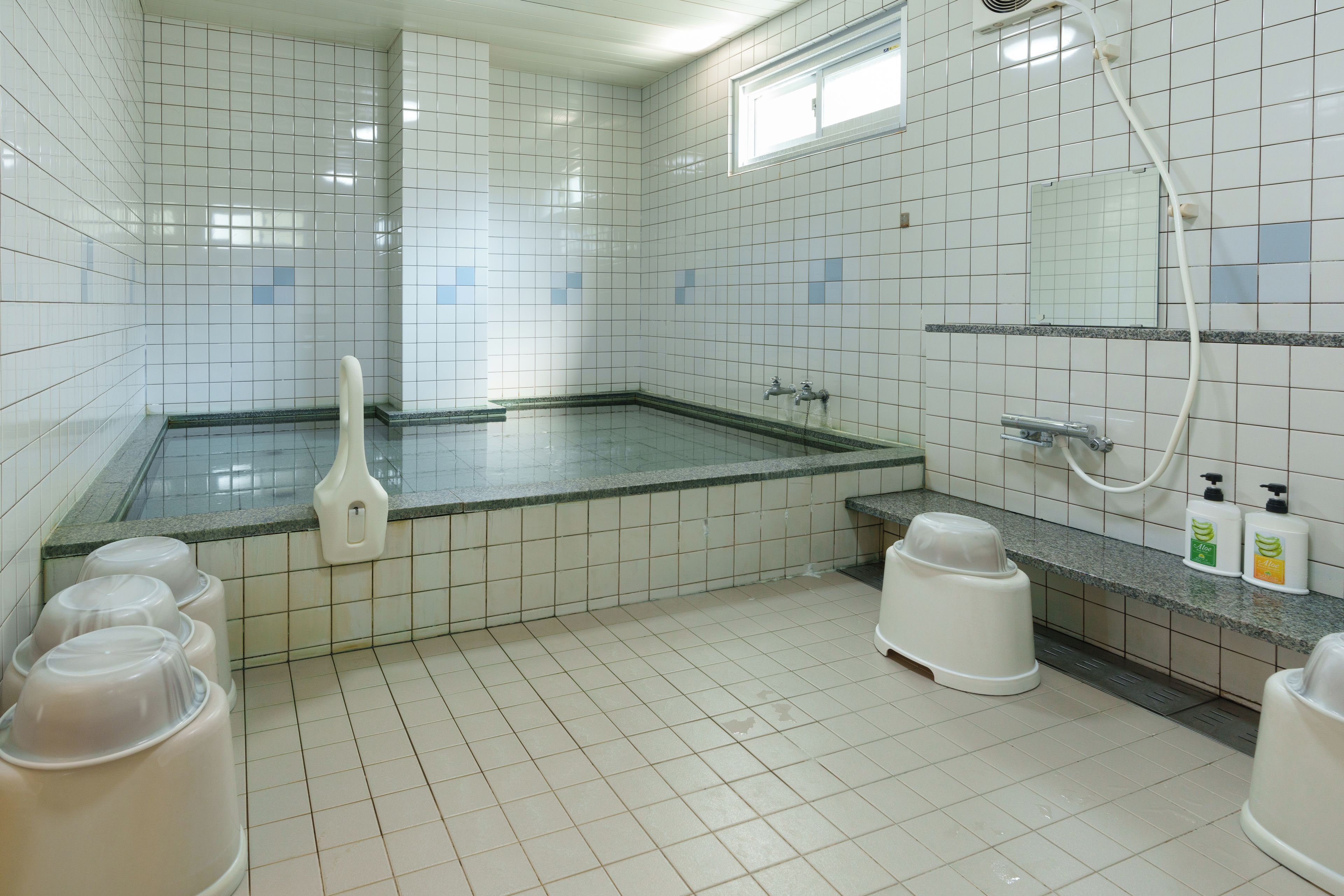 A clean, tiled bathroom with a shower, a toilet, and a sink.