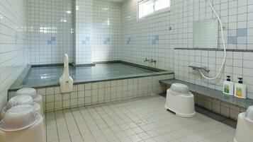 A clean, tiled bathroom with a shower, a toilet, and a sink.