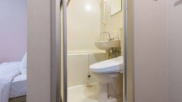 Une salle de bain avec des toilettes, un lavabo et une douche.