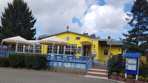 A yellow building with a sign reading "Sonnenterasse." - Small Bungalow Wiesenperle - Small Bungalow meadow pearl (Trassenheide)