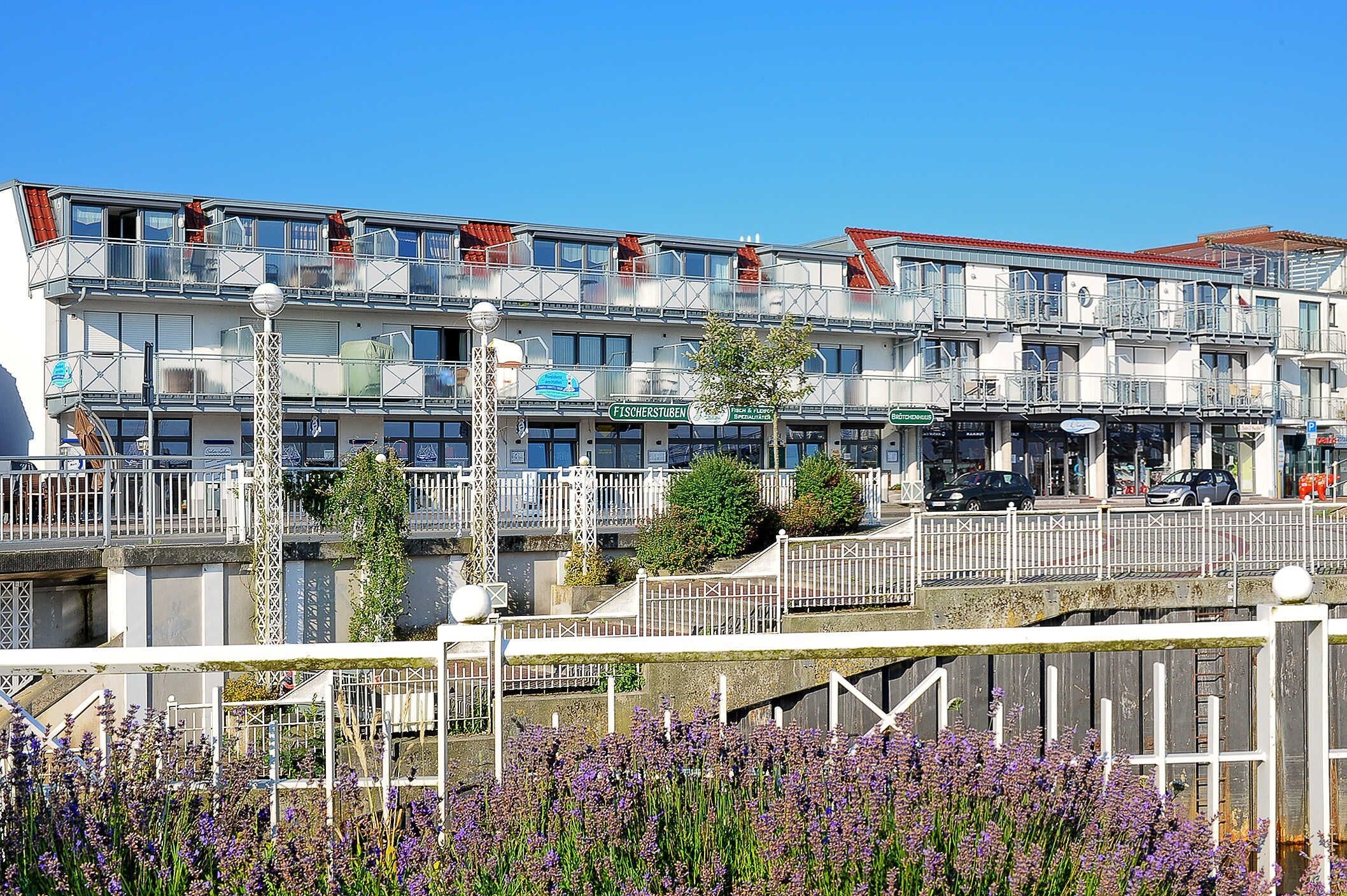 Un immeuble à plusieurs étages doté de balcons, d’un restaurant et d’un espace de stationnement.