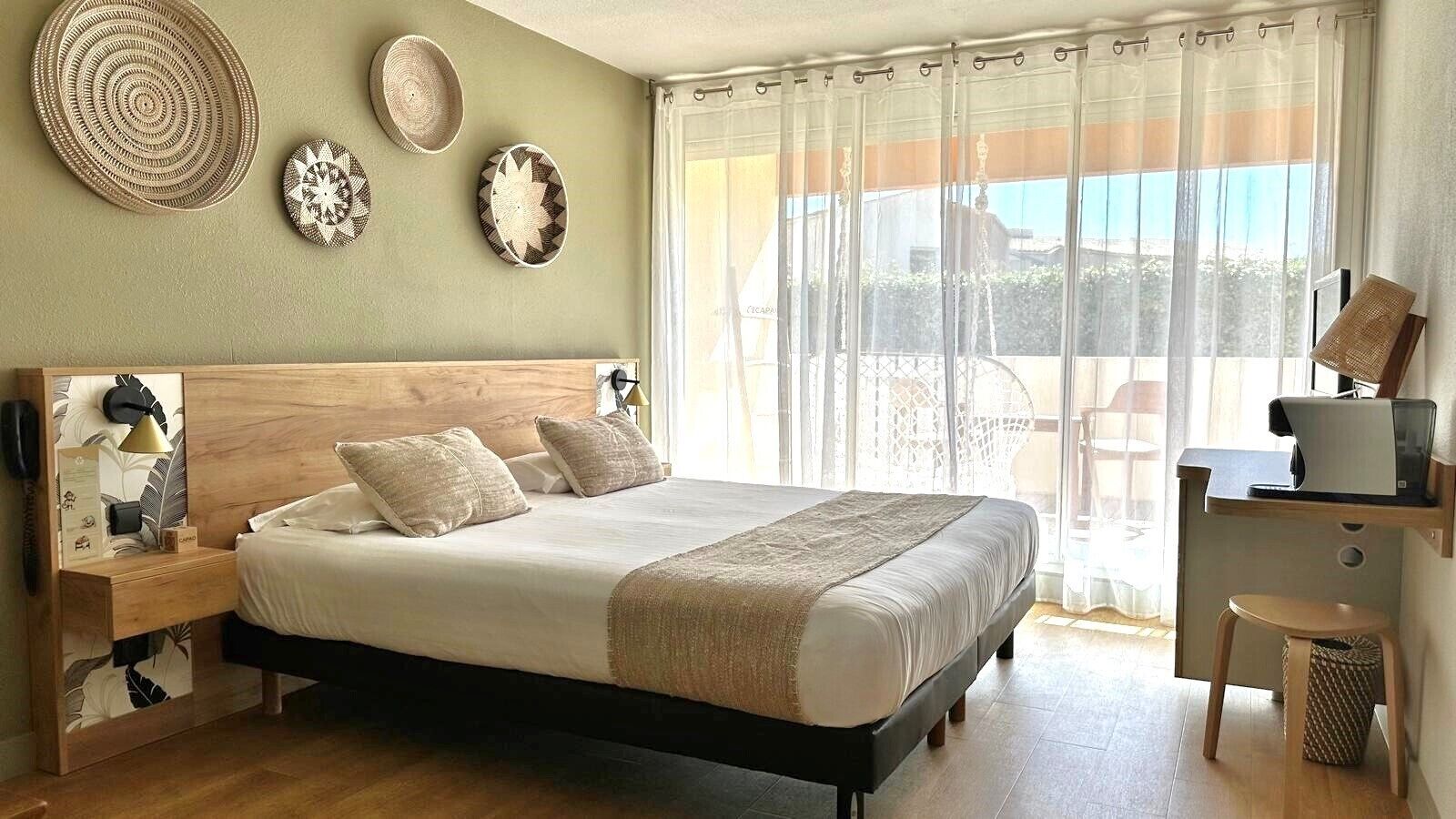 Une chambre à coucher avec un lit en bois, une table de chevet, un bureau avec une chaise et une fenêtre avec des rideaux.
