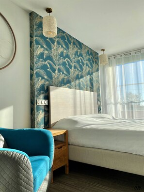Relax in a serene bedroom with a large bed, nightstand, and comfortable chair.