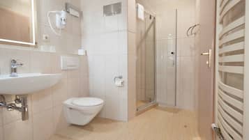 Ein modernes Badezimmer mit Waschbecken, Toilette und Duschkabine aus Glas.