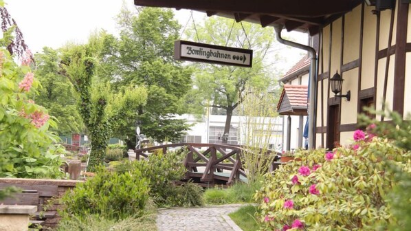 Un sendero en un jardín que lleva a un edificio con un letrero que dice "Bowlingbahnen oo".