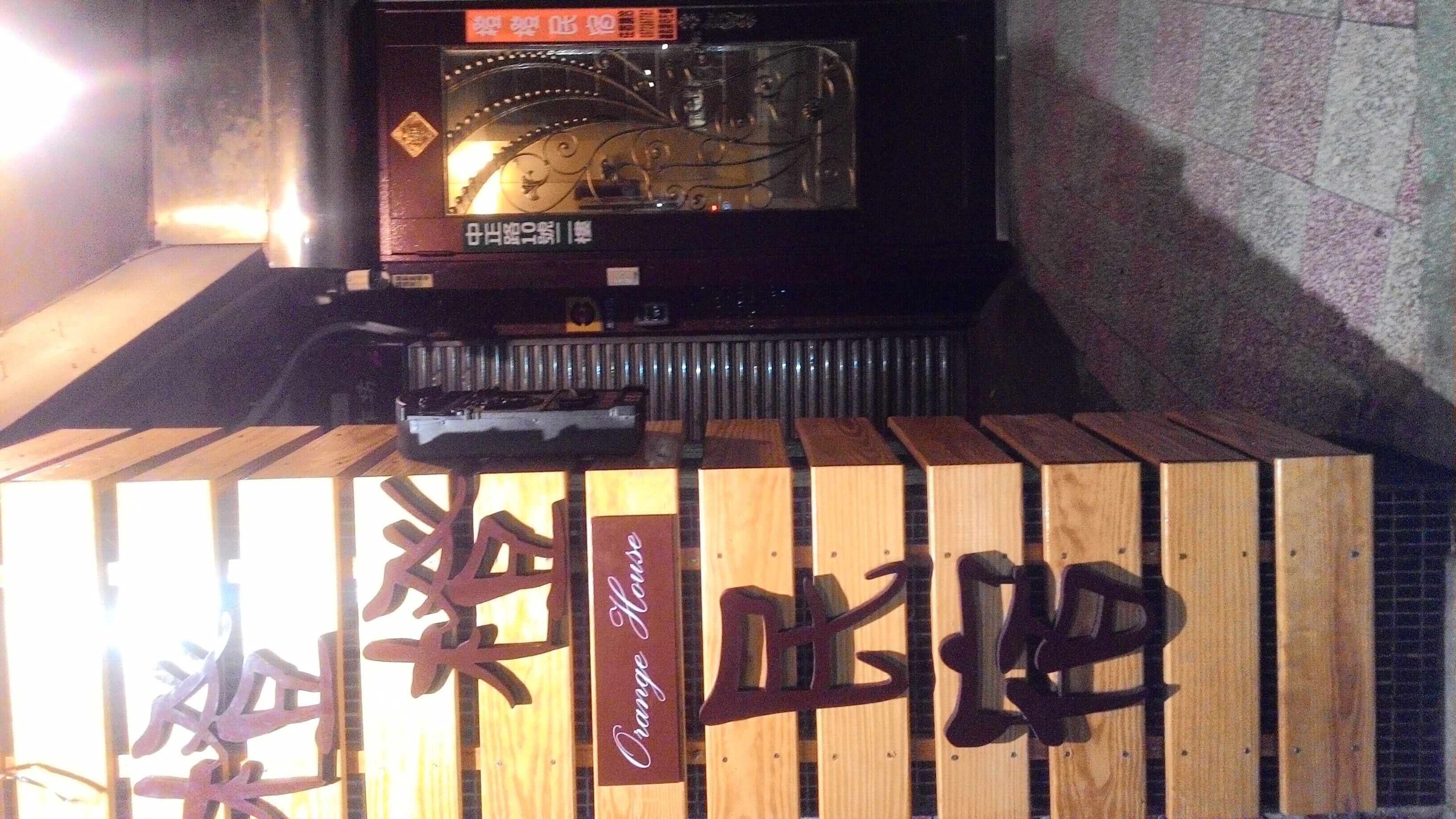 A wooden structure with Chinese characters and a sign that reads "Orange House."