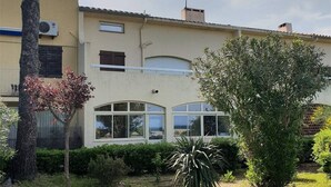 Un edificio a due piani con tetto piatto, ampie finestre e un piccolo balcone.