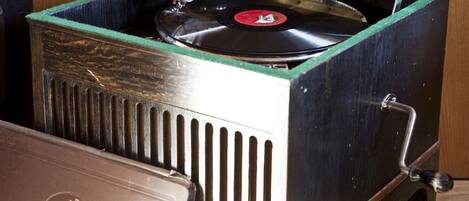 A vintage record player with a green top and a black base, placed on a wooden surface.