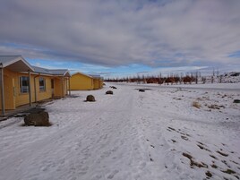 Filas de cabañas amarillas sobre un terreno nevado y cielo despejado.