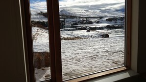 A window with a view of a snowy landscape, a bridge, and a mountain. - Fossatún Country Hotel (Borgarbyggd)