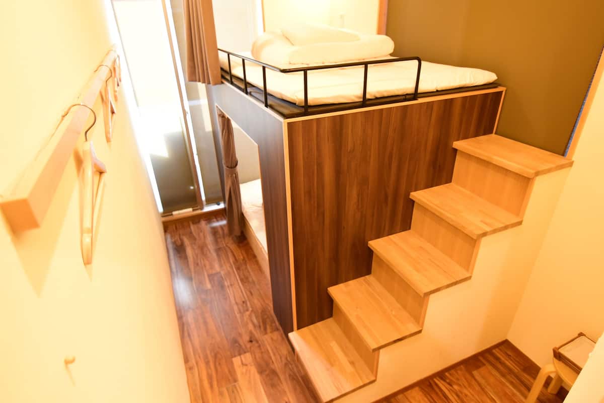 Eine Treppe mit Holzboden und einem Etagenbett oben.