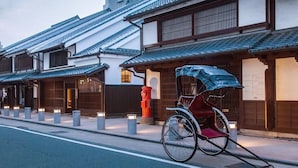 Um edifício tradicional japonês com uma bicicleta estacionada em uma cobertura frontal.