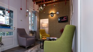 Un salon avec une cheminée, un canapé, une table basse et un téléviseur fixé au mur.