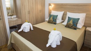 Une chambre d’hôtel avec un lit, une armoire en bois et un miroir.
