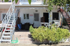A building with a white exterior, a staircase, and a small garden area. - Haraki Dream View (Rhodes)